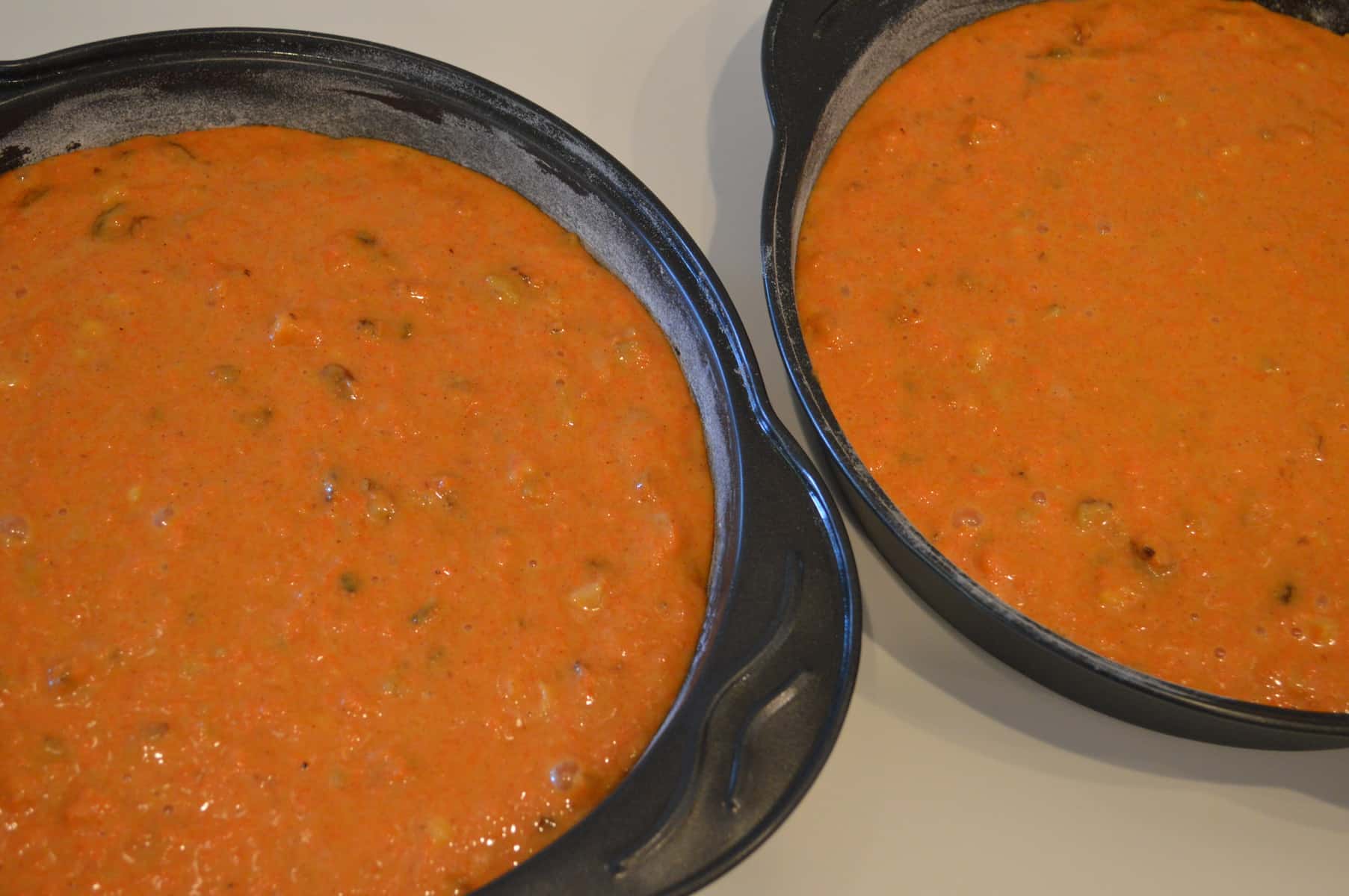 Carrot Pineapple cake batter in two greased cake pans 