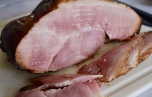 sliced ham on a white cutting board
