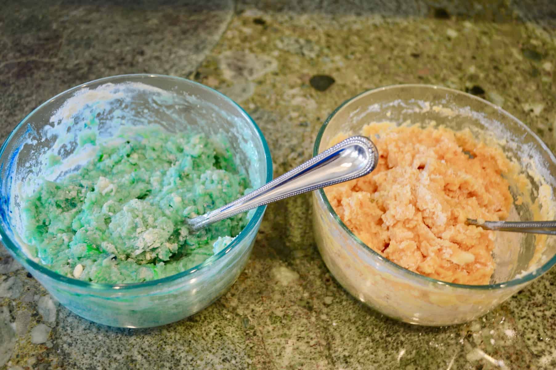 teal and orange homemade play doh in bowls on a counter 