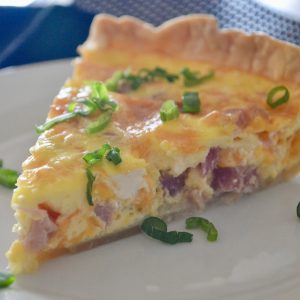 Ham and Cheese Quiche is an easy make-ahead healthy breakfast brunch egg recipe! Made with pie crust, ham, cheddar, and eggs, this can be frozen ahead. Great for baby showers, brunches, bridal showers, Christmas Morning, and Easter. #weekdaybreakfast #breakfast #brunch #hamandcheese #eggs #quiche #piecrust #ChristmasMorning #easyrecipe #healthy #parenting #kidsfood