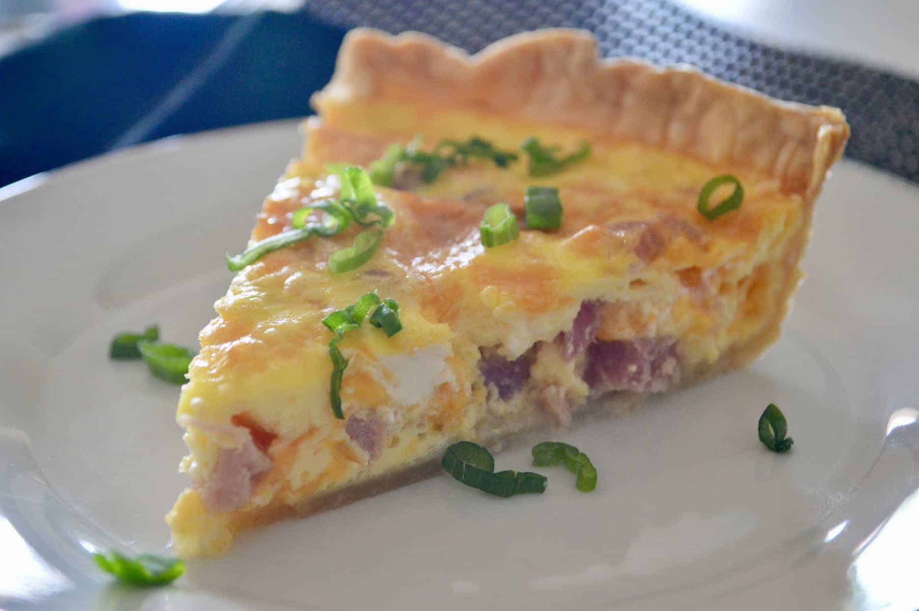 Ham and Cheese Quiche is an easy make-ahead healthy breakfast brunch egg recipe! Best Brunch Recipes. Made with pie crust, ham, cheddar, and eggs, this can be frozen ahead. Great for baby showers, brunches, bridal showers, Christmas Morning, and Easter. #weekdaybreakfast #breakfast #brunch #hamandcheese #eggs #quiche #piecrust #ChristmasMorning #easyrecipe #healthy #parenting #kidsfood