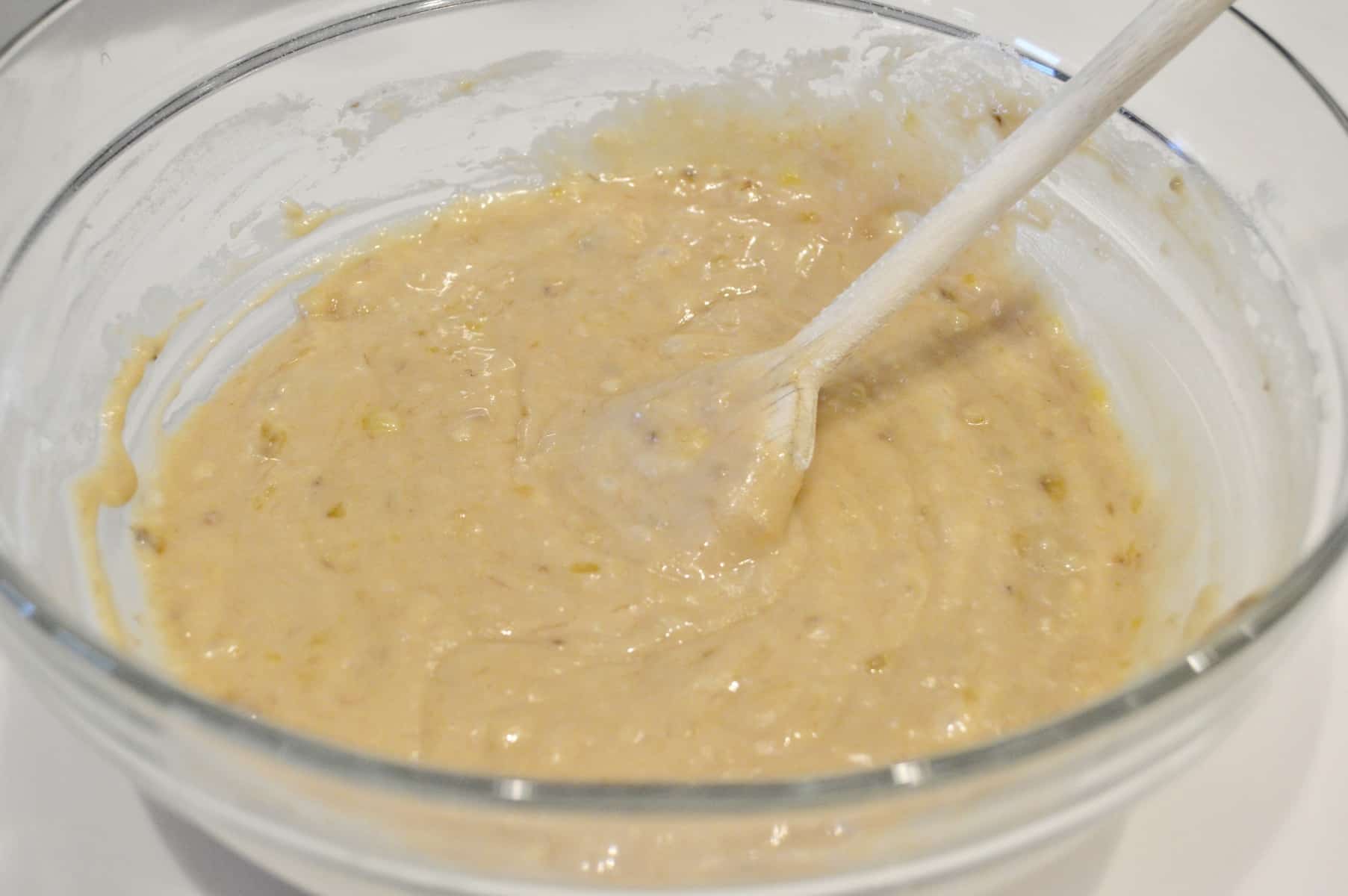 batter in a clear bowl with a wooden spoon. 