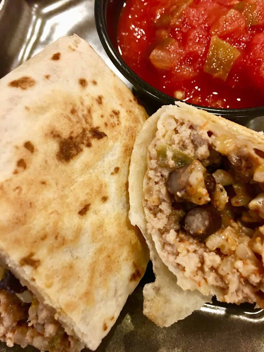 Freezer Burritos with ground turkey, brown rice, black beans, and cheddar cheese is an easy recipe for make ahead burritos that you freeze. Healthy and full of protein, these are a great weeknight dinner or meal prep food. #freezerfoods #freezerburritos #burritos #makeahead #mealprep #groundturkey #healthy #parenting #protein #easyrecipe #weeknightdinner #blackbeans