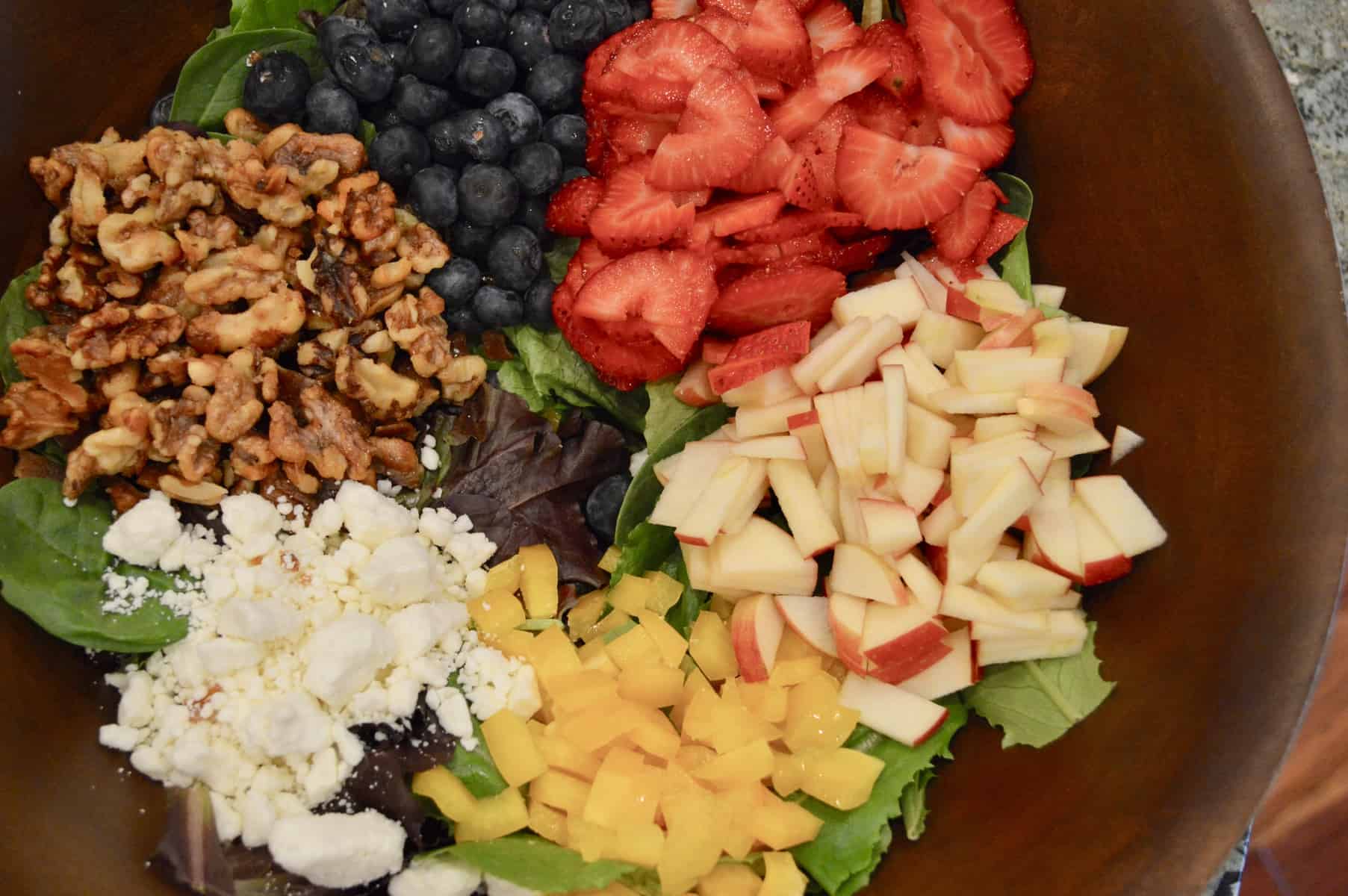all the ingredients in a large wooden salad bowl. 