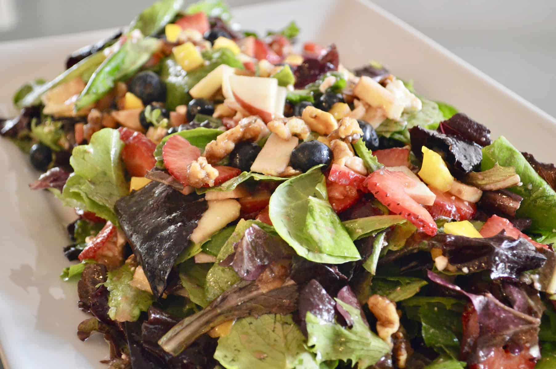 Berry Salad with Candied Walnuts on a white serving dish