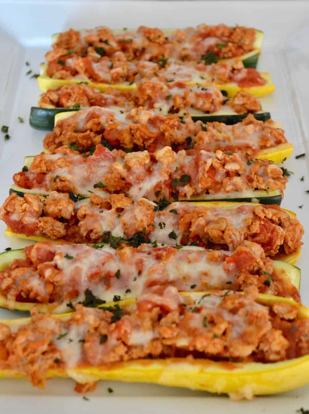 ground turkey stuffed zucchini on a white plate 