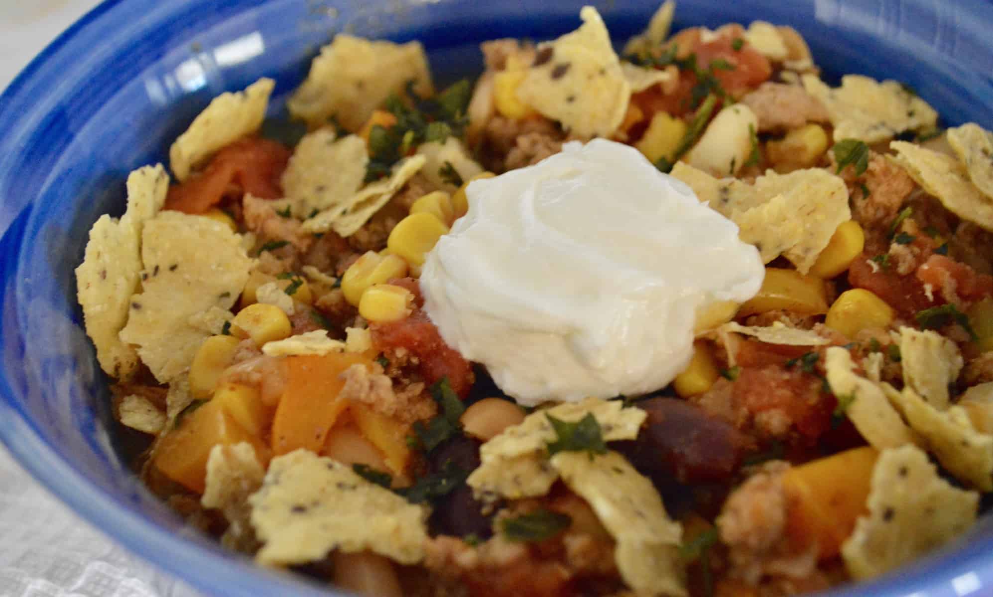 Healthy Turkey Chili with hominy and beans in a blue bowl