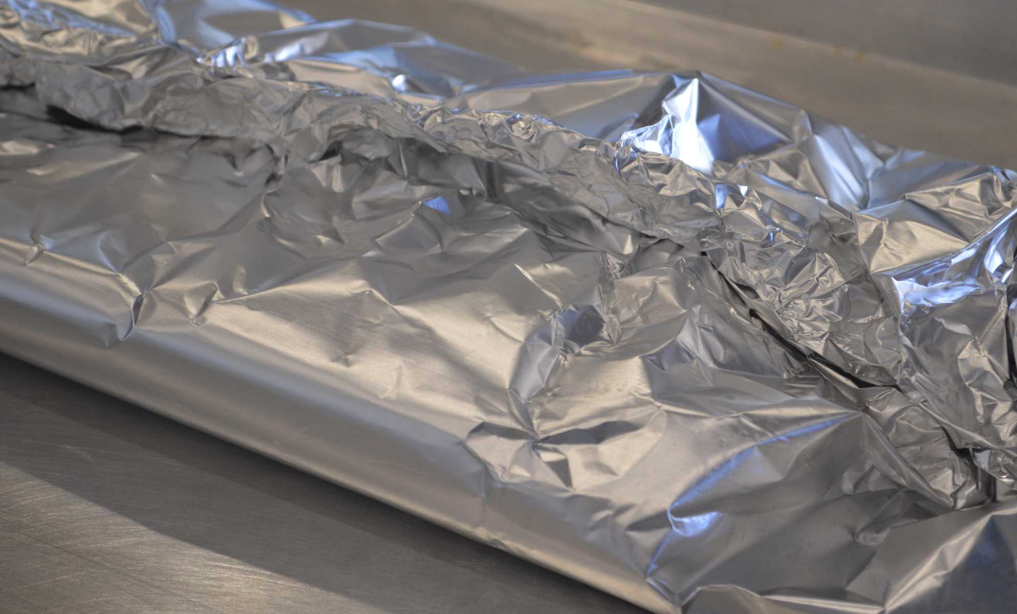 aluminum wrapped around fish on a baking pan. 
