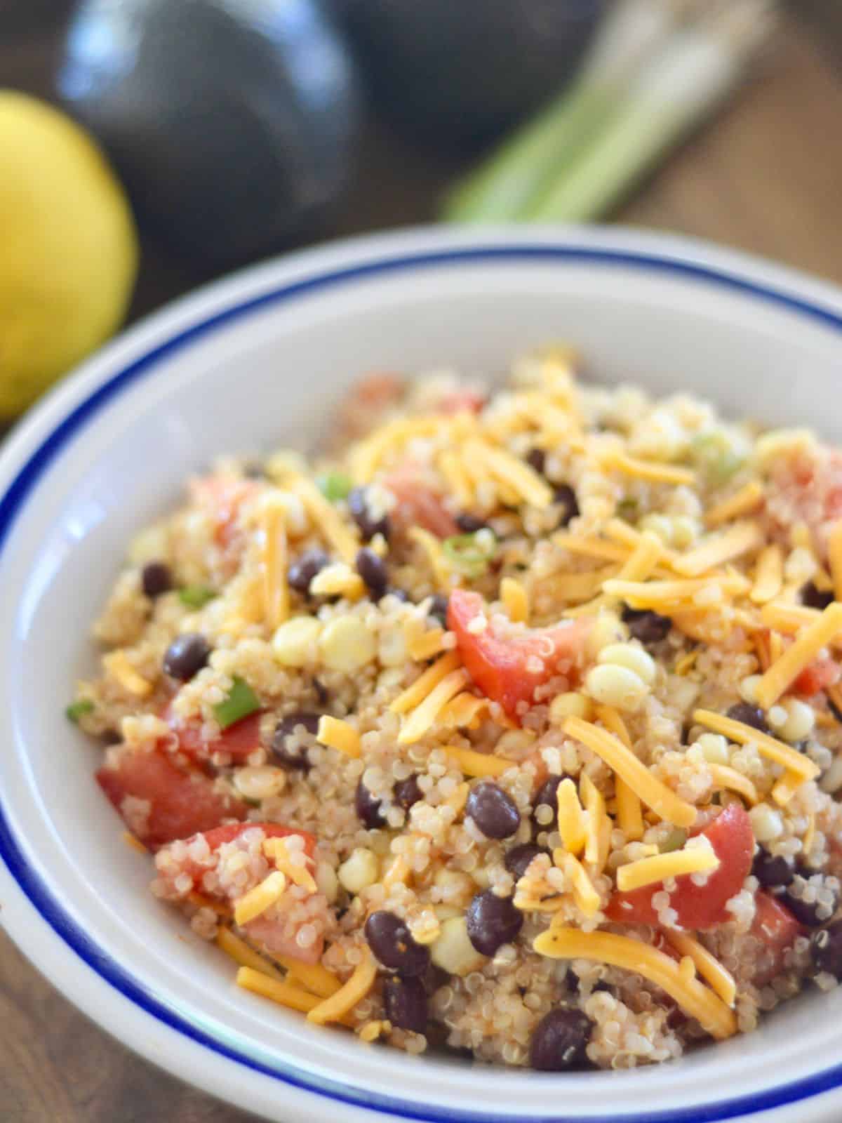 Mexican Quinoa Salad recipe with corn and black beans in a white bowl. 