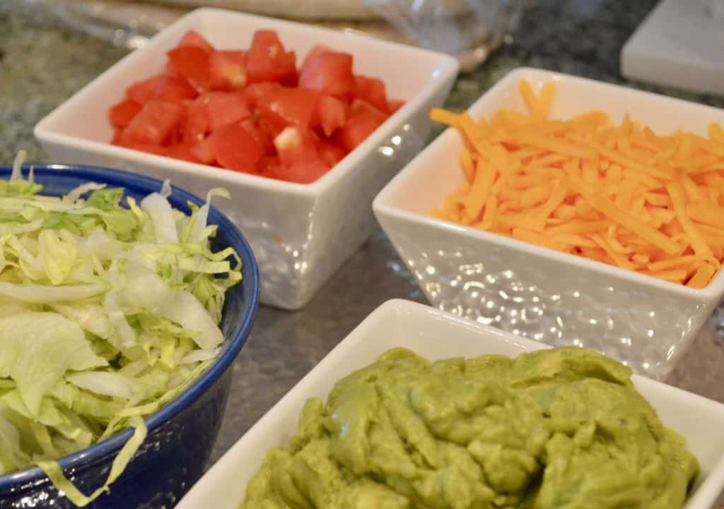 toppings  include shredded cheese, guacamole, lettuce, tomatoes and sour cream