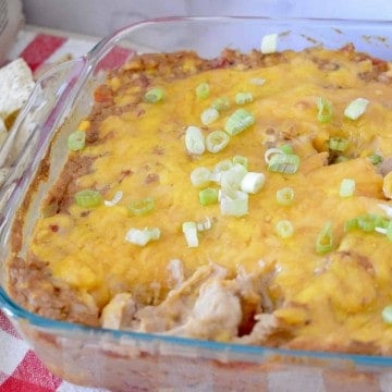 Cream Cheese Bean Dip in a glass pan with green onions on top.