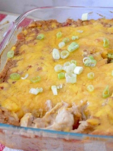 Cream Cheese Bean Dip in a glass pan with green onions on top.