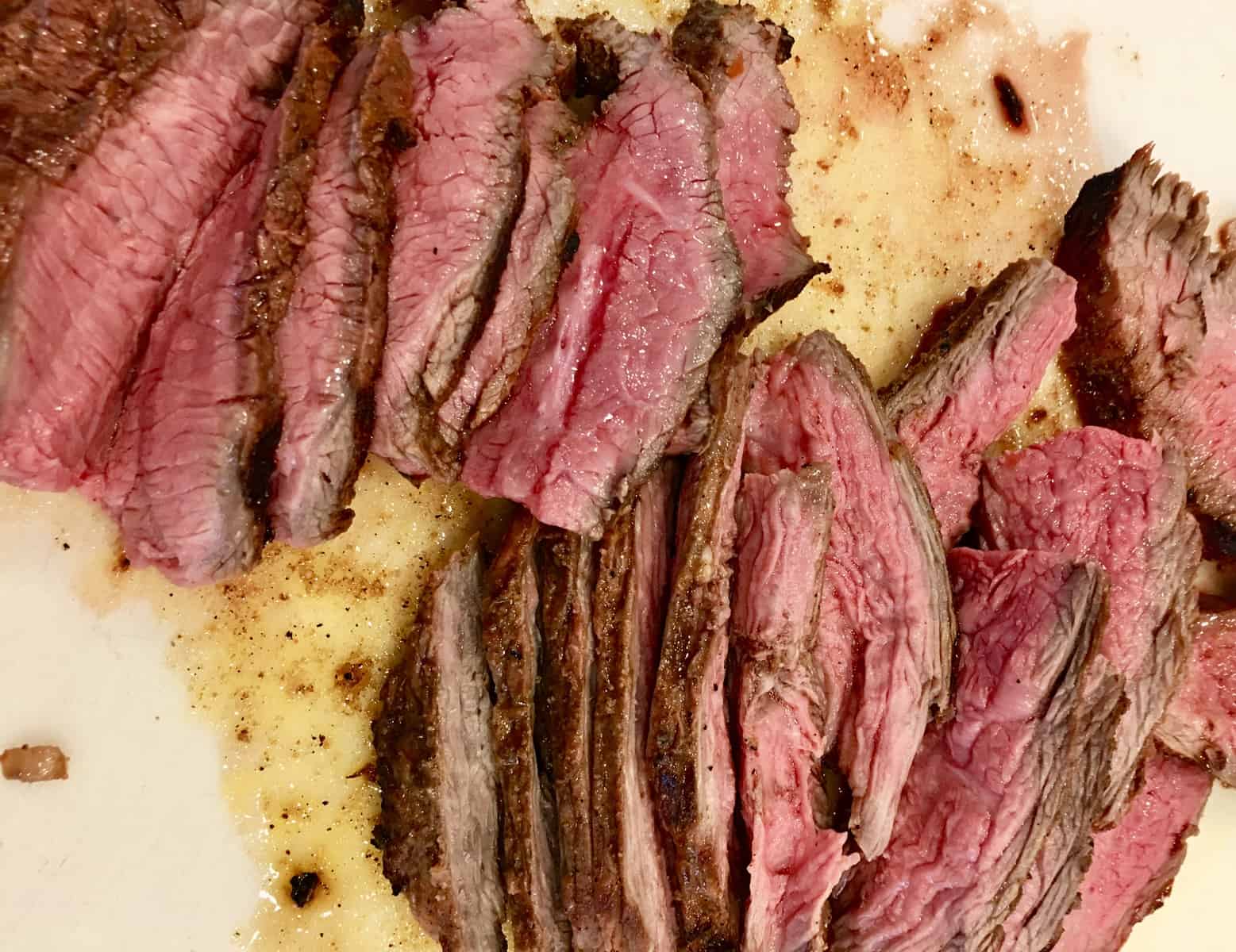 Carne Asada Marinade recipe with cut up flank steak on a cutting board