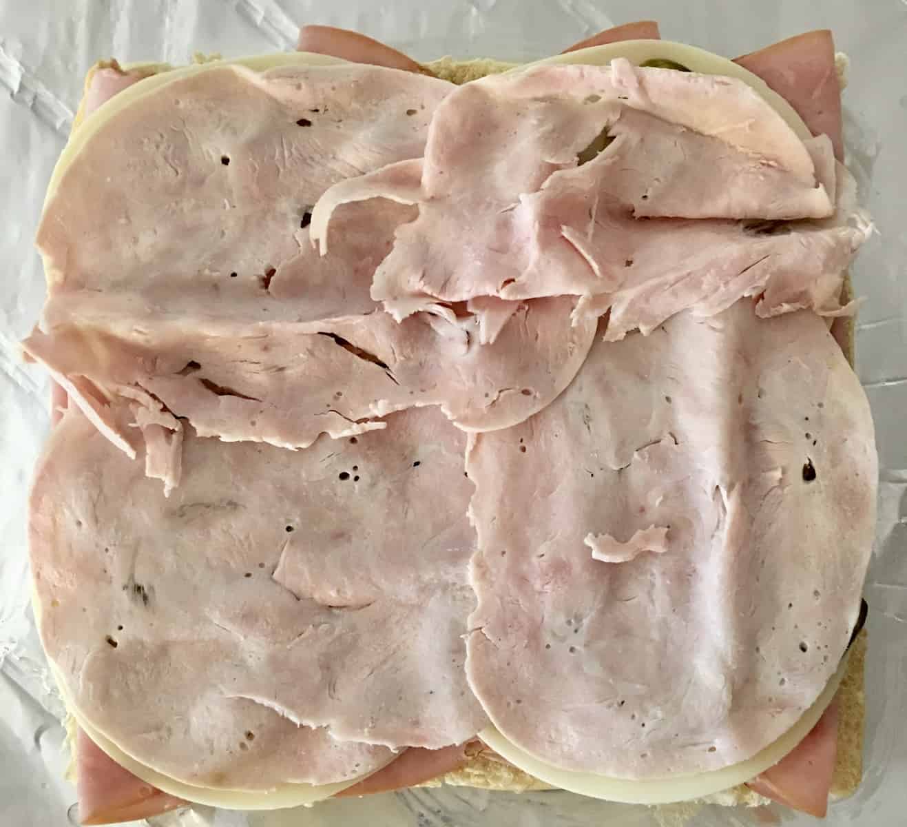 turkey layer on the ham and cheese sliders 