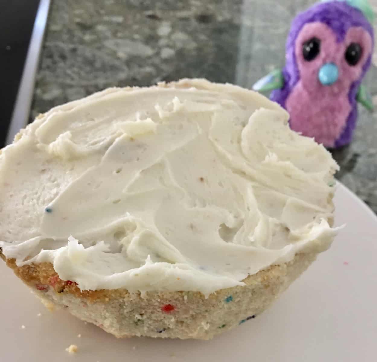 Frost the half sphere top of the hatchimals cake. 