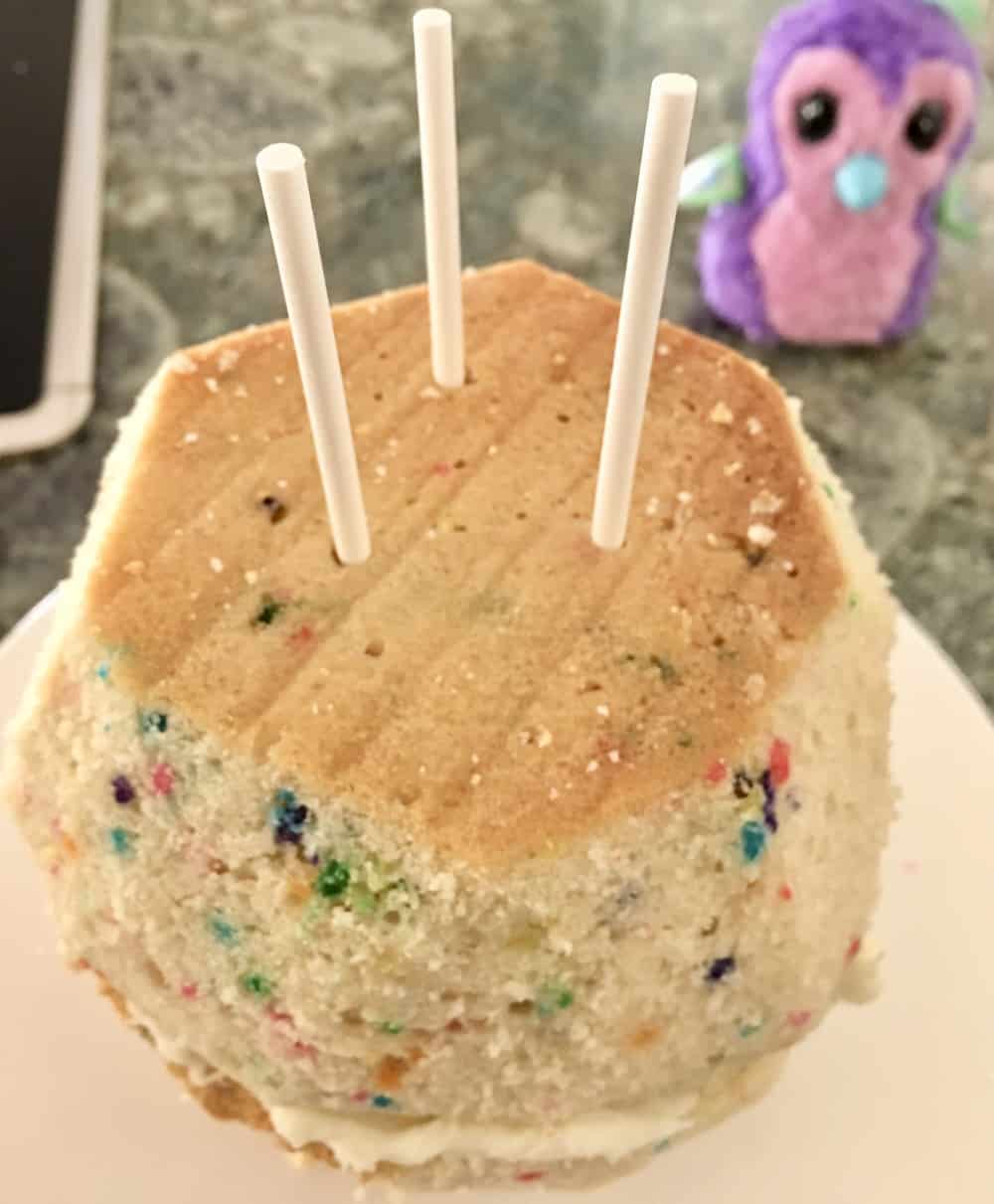 insert three skewers down the body of the hatchimals cake. 