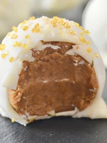 pumpkin spice truffles with white chocolate coating on a black plate