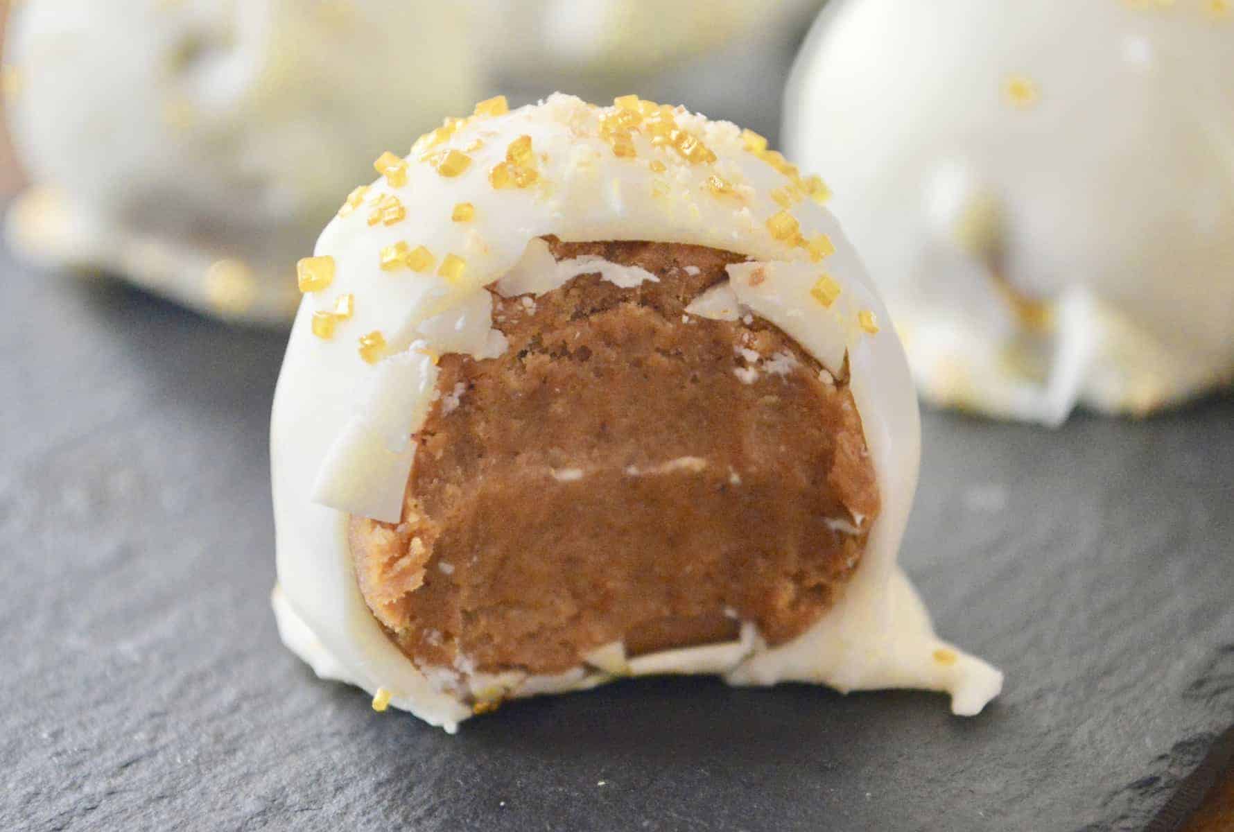 pumpkin spice truffles with white chocolate coating on a black plate