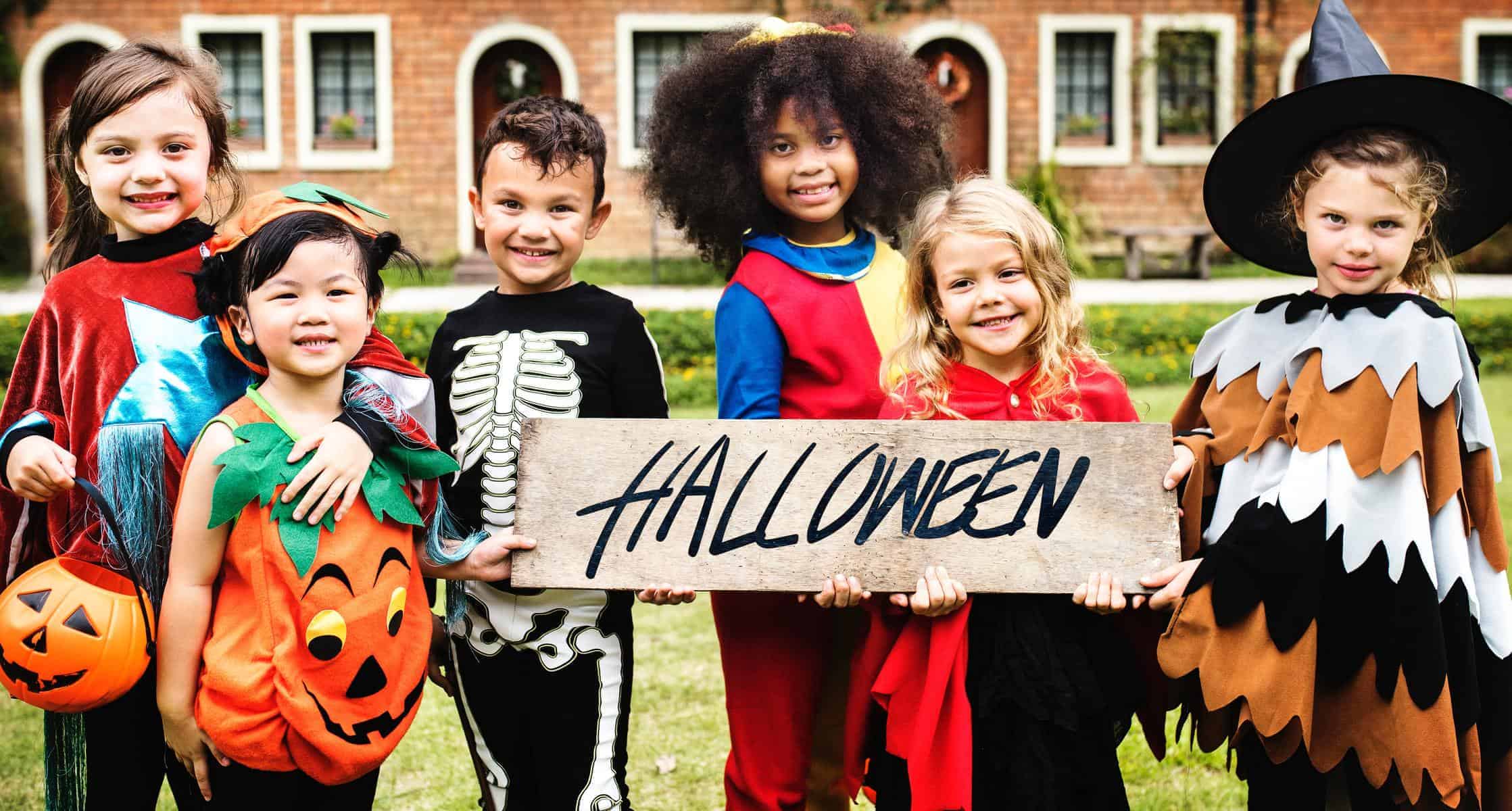 kids holding a halloween sign.  