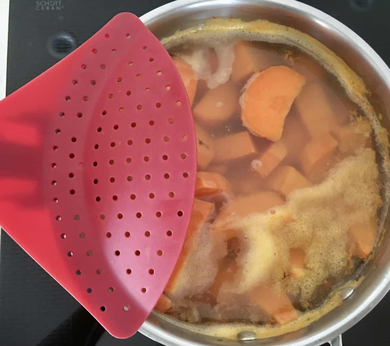 boiled yams in a pot with a strainer attached. 