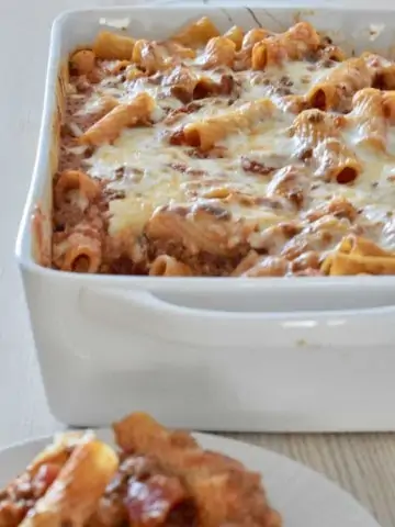 Baked Ziti with meat sauce in a white baking dish.