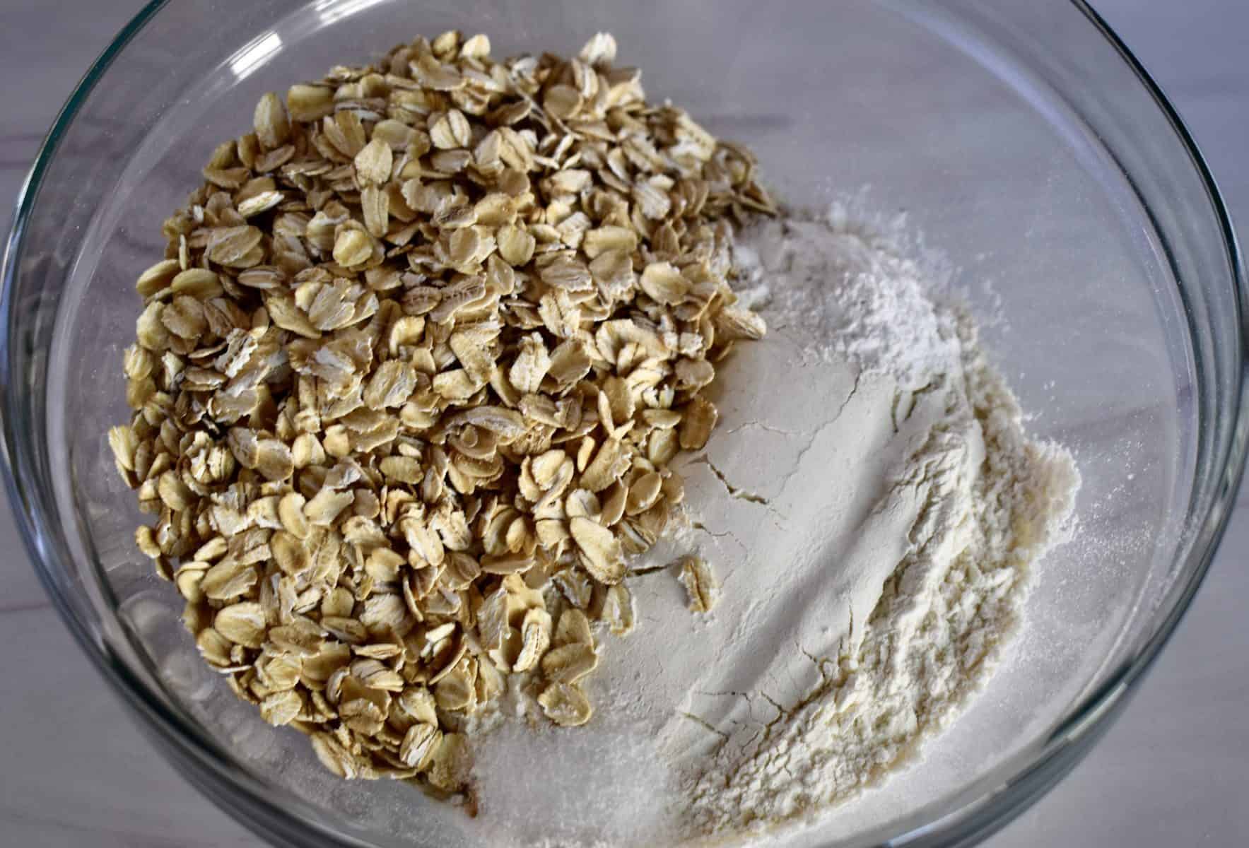 overhead photo of flour, oats, baking powder, and salt in a glass bowl. 