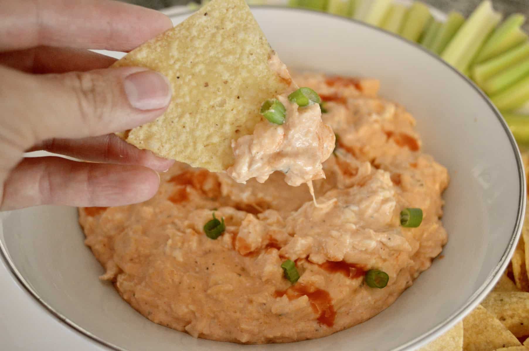 tortilla chip with buffalo chicken dip on it. 