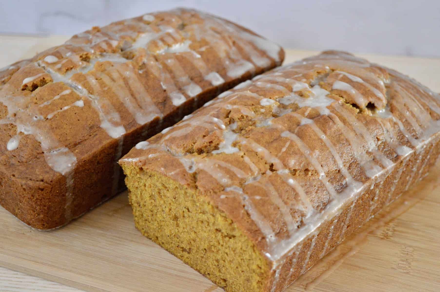 glazed pumpkin bread on a wooden cutting board. 