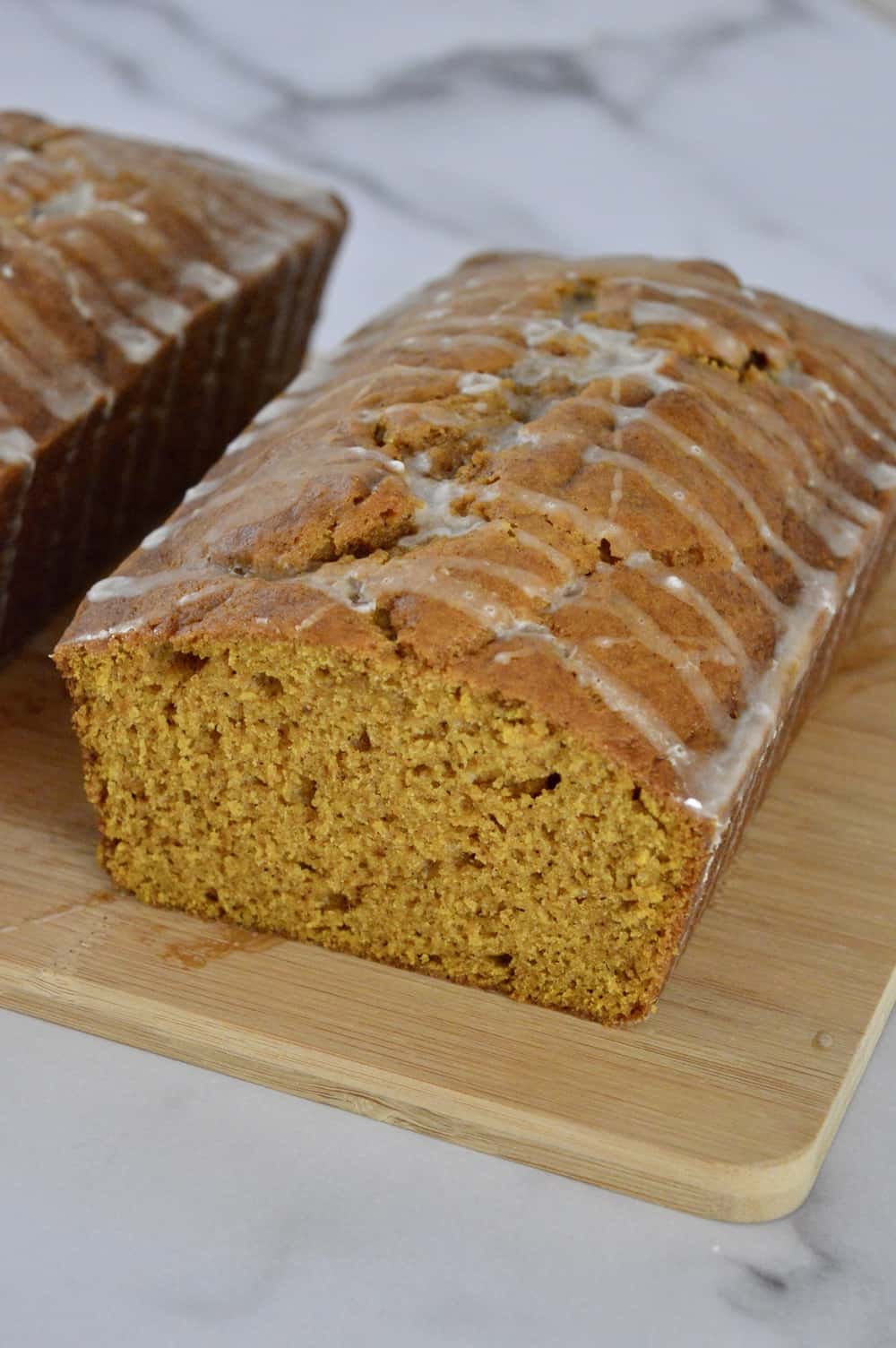 glazed pumpkin bread on a cutting board.