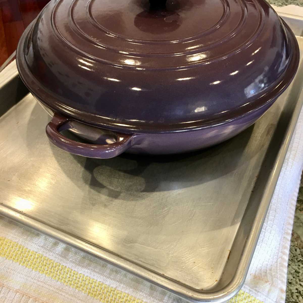 weighing down the eggplant to draw moisture out of it using a heavy pan. 