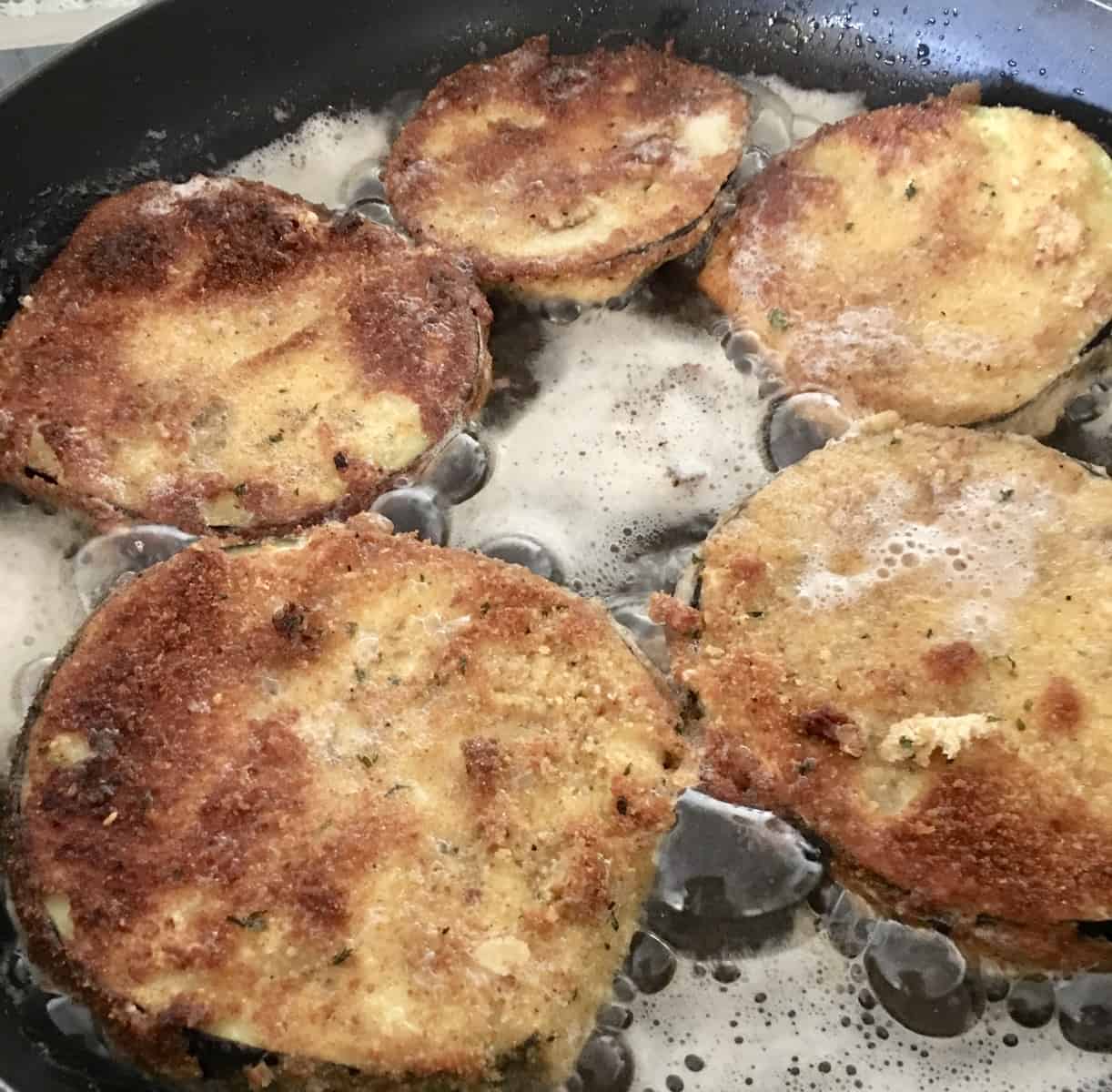 pan on the stove frying the meal. 