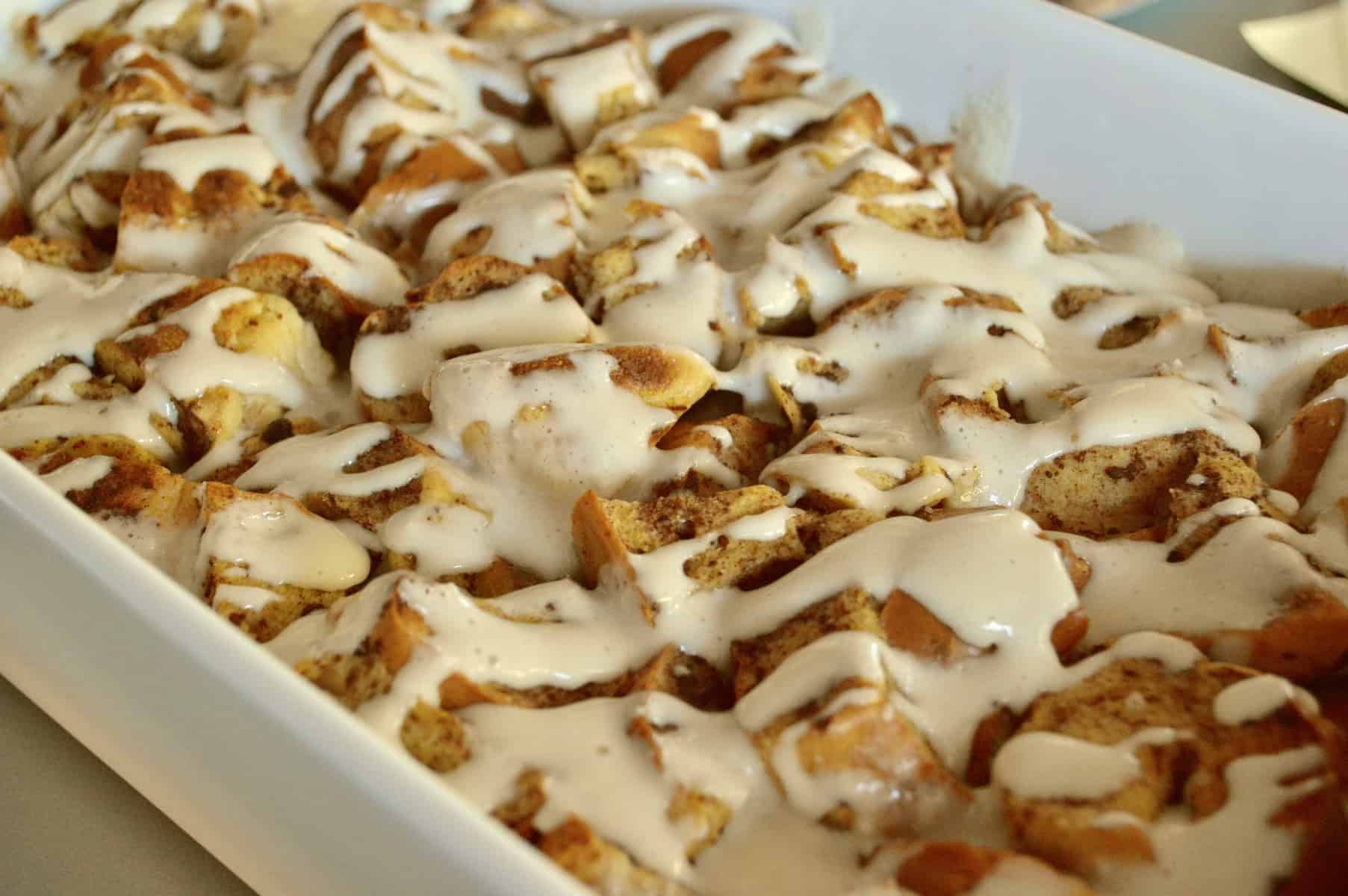 overnight bagel French toast casserole with a cream cheese maple glaze poured overtop. 