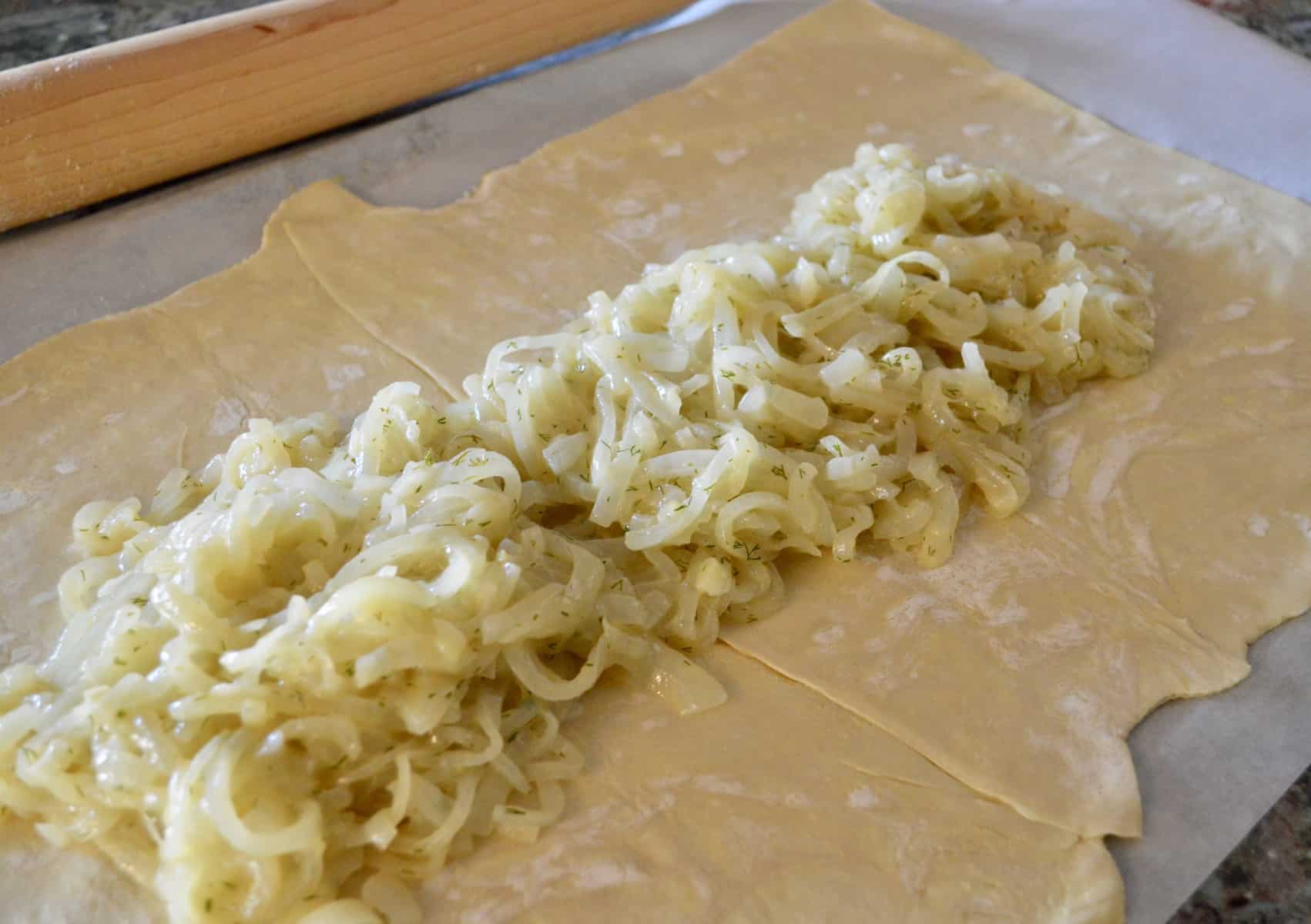 Onion and dill mixture on puff pastry for Salmon Wellington 