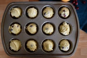 batter in muffin tin for cranberry orange muffins.