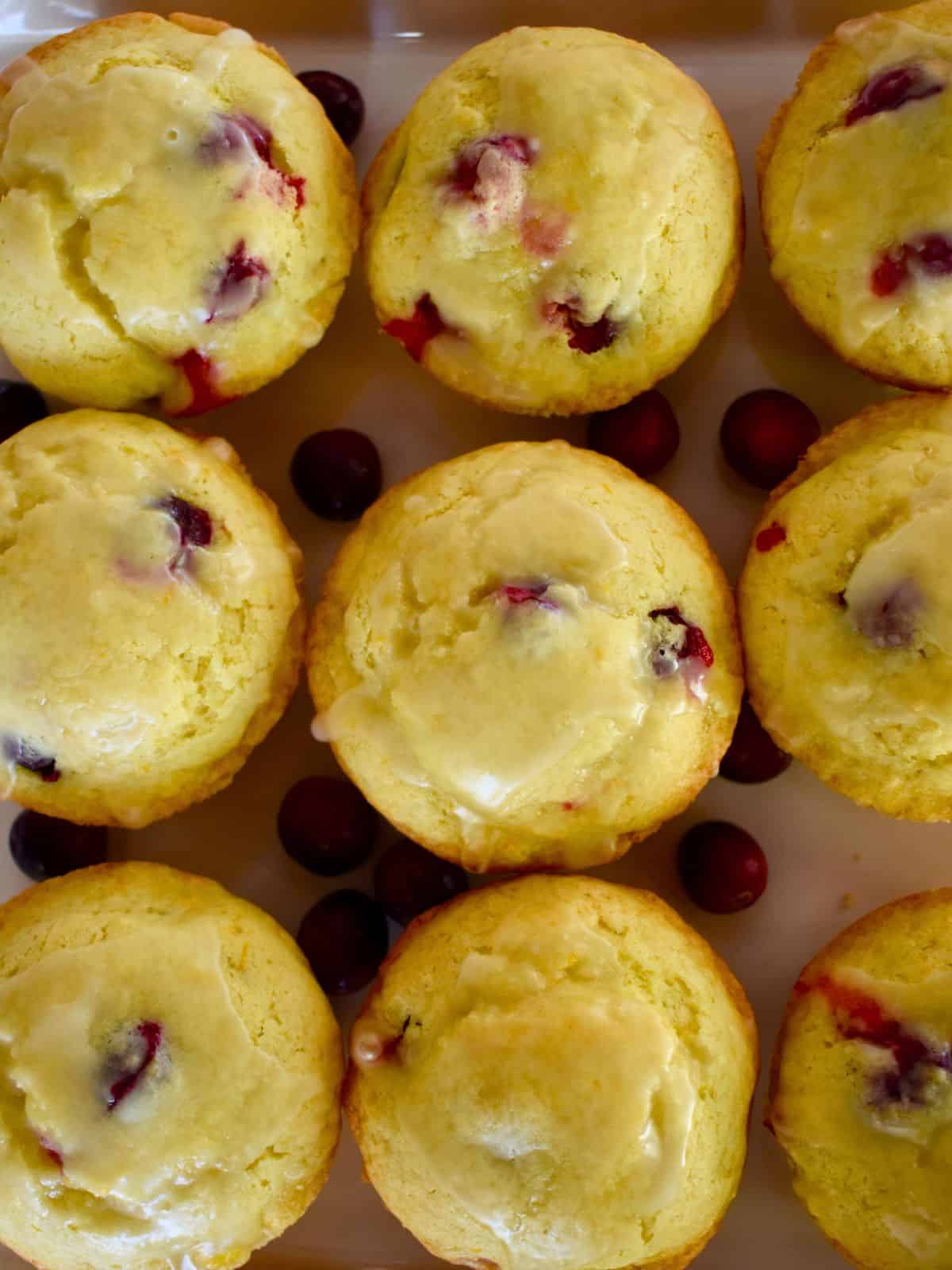 overhead photo of glazed cranberry orange muffins on a plate. 