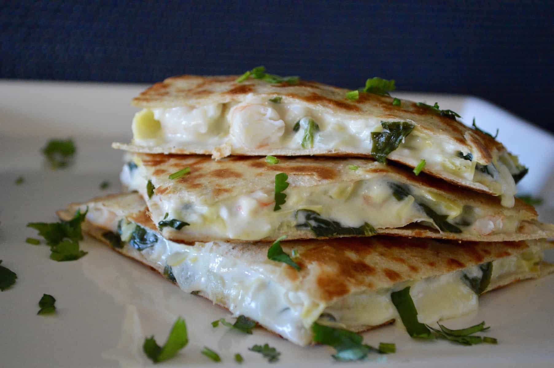 Spinach Artichoke Shrimp Quesadillas on a white plate with cilantro sprinkled 
