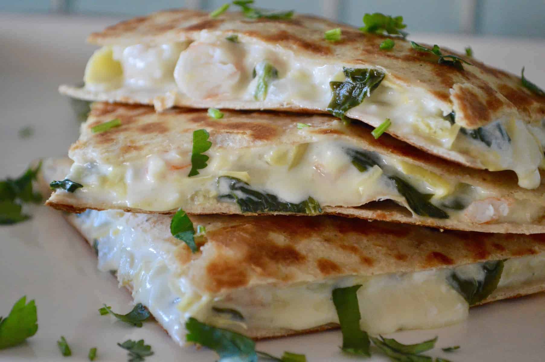 Spinach Artichoke Shrimp Quesadillas on a white plate with cilantro sprinkled over top