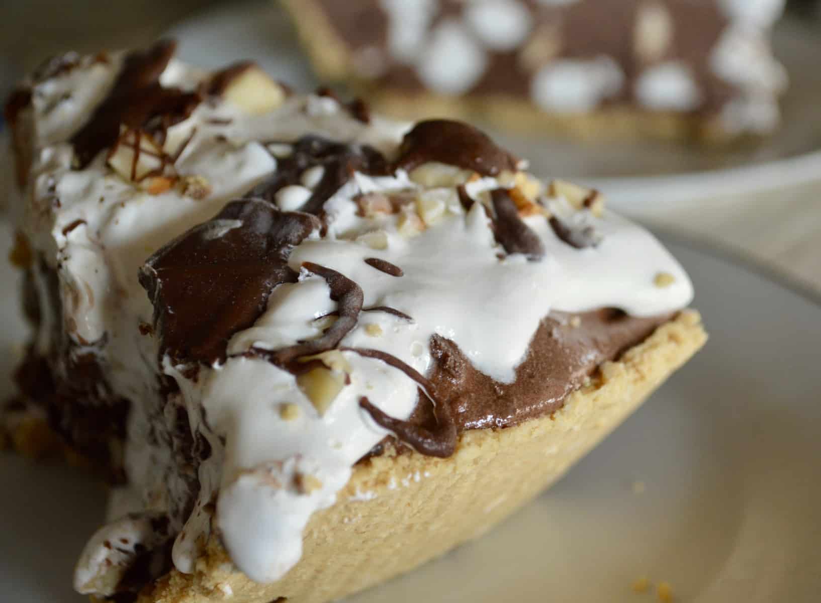 Graham Cracker crust with marshmallows and topping on a white plate. 