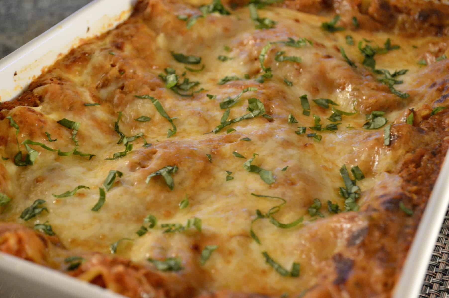 Easy Vegetable Lasagne Recipe in a white baking dish with basil sprinkled on top