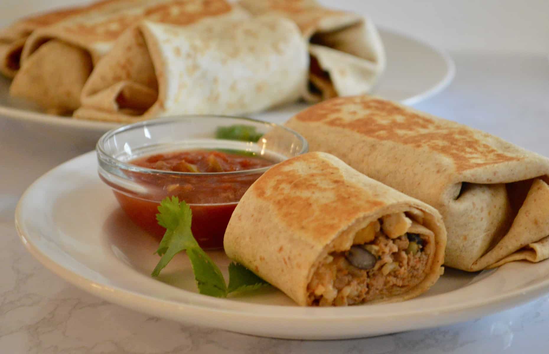 freezer burritos cut in half on a white plate 