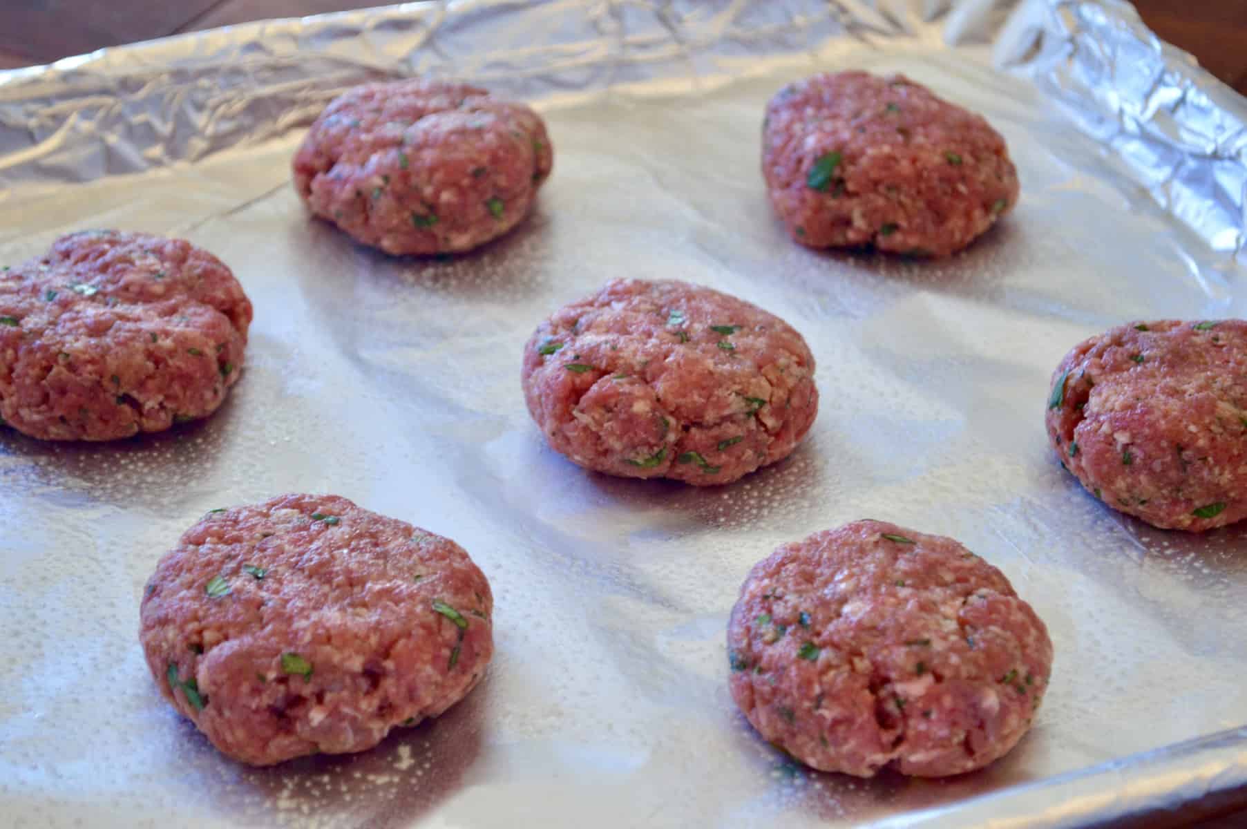 meat flattened on a greased baking sheet