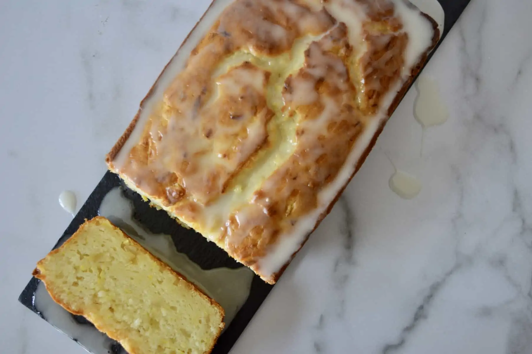 summer squash bread with glaze on a black platter