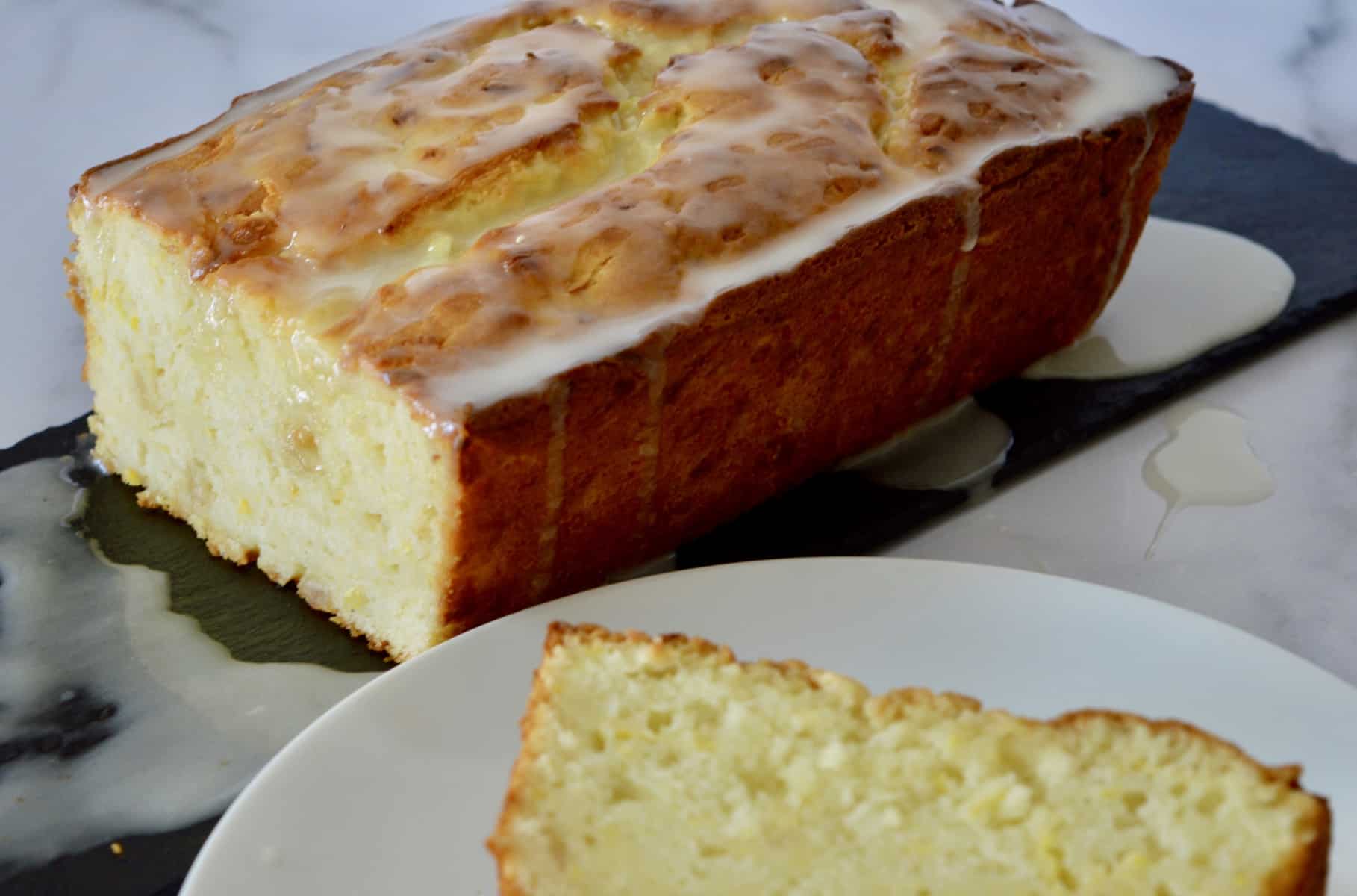 loaf on black plate with glaze drizzled overtop 