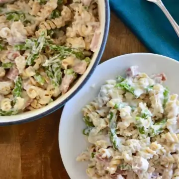 Creamy Ham and Asparagus Pasta in a white plate on a wooden tray