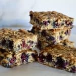 Blueberry Banana Oat Bars stacked on each other on a white background