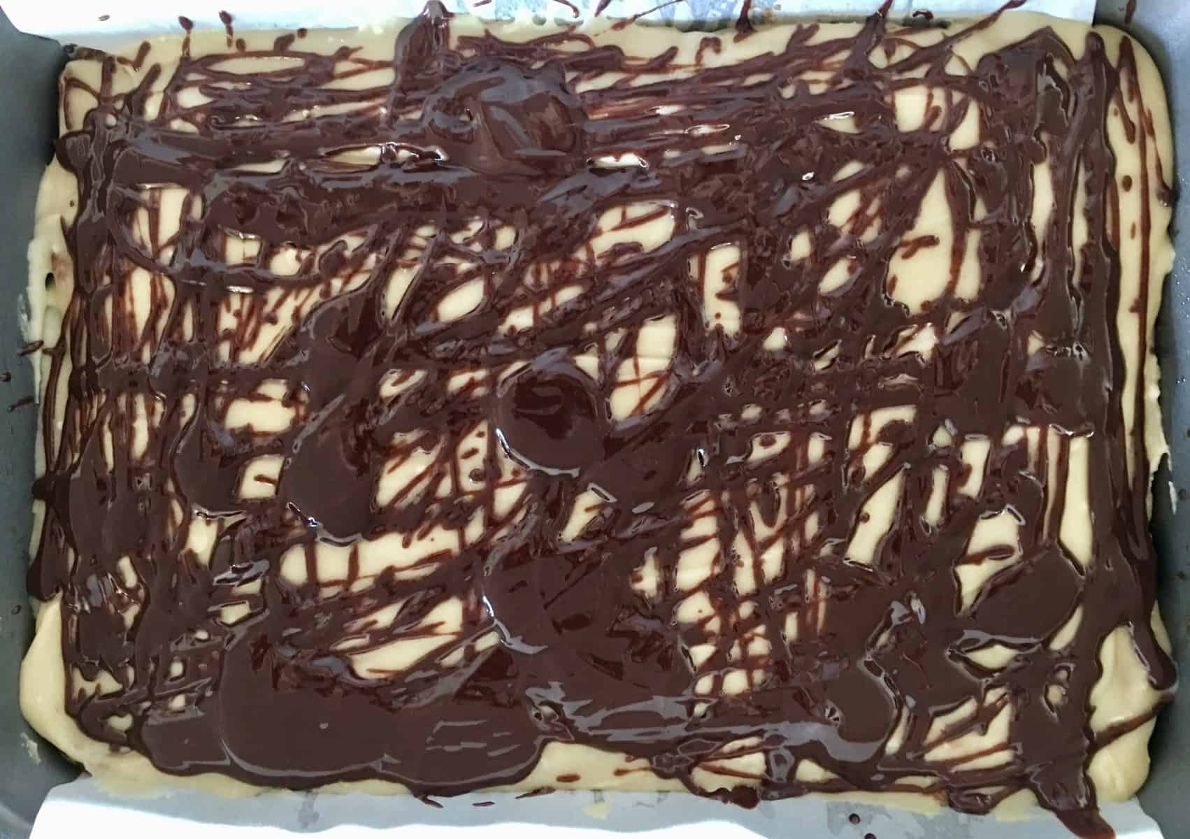 Chocolate drizzle over cooled bars in a pan. 