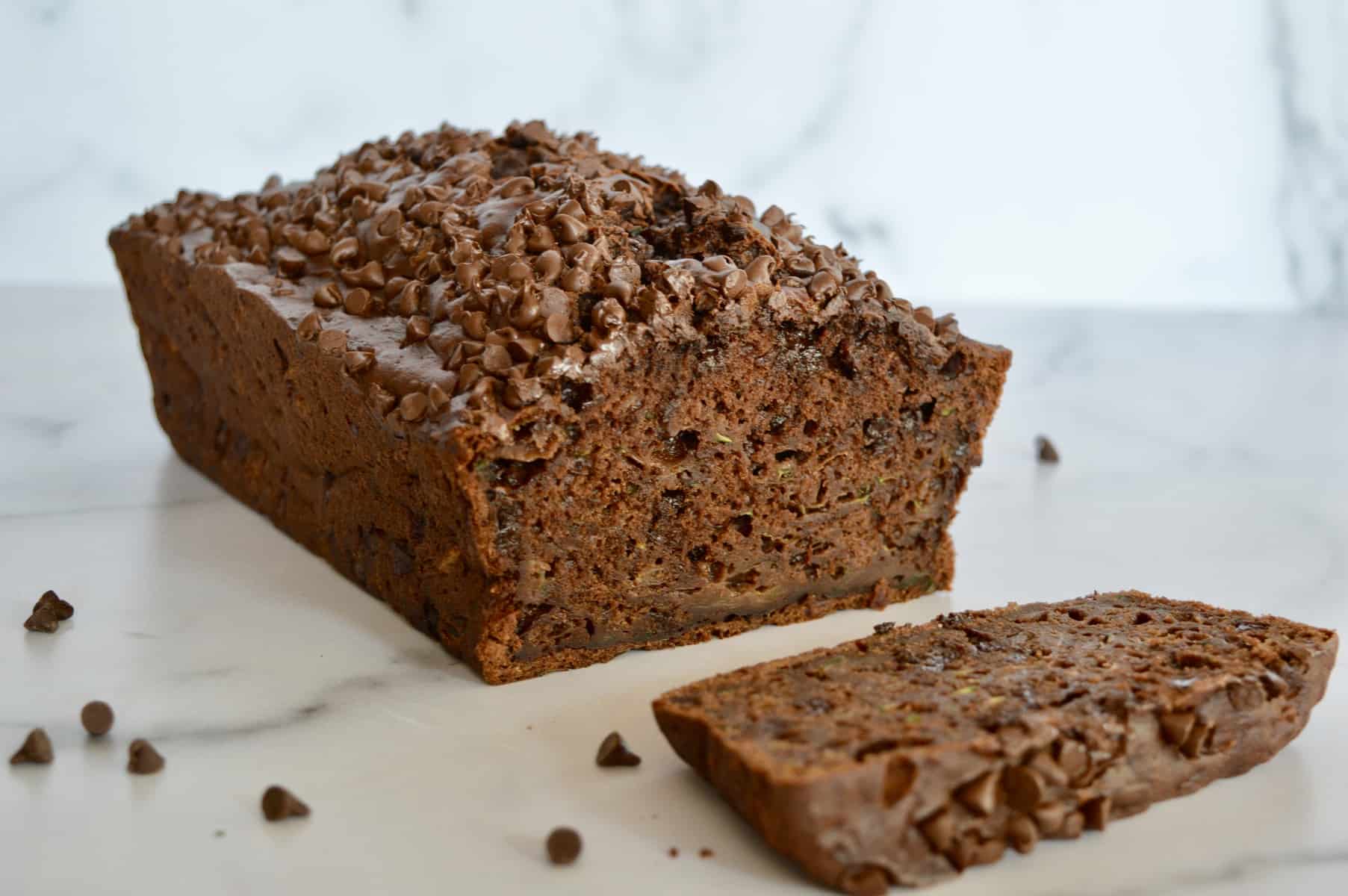 chocolate zucchini banana bread on a counter with a slice cut