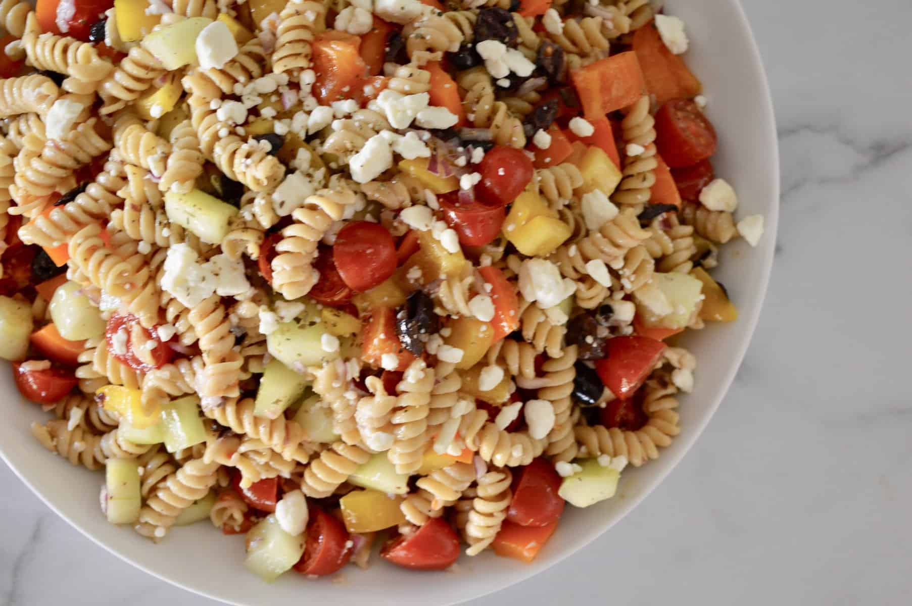 Whole Grain Greek Pasta Salad in a white bowl. 