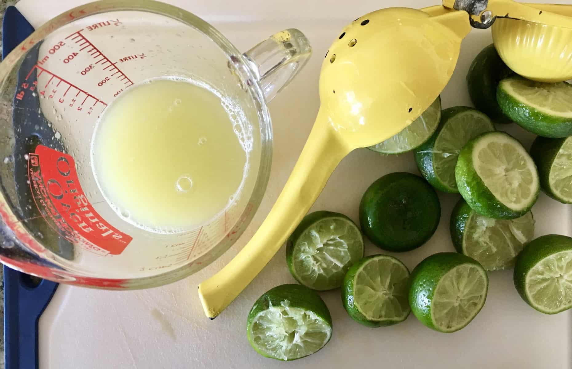 cutting board with limes and lime juice on it.
