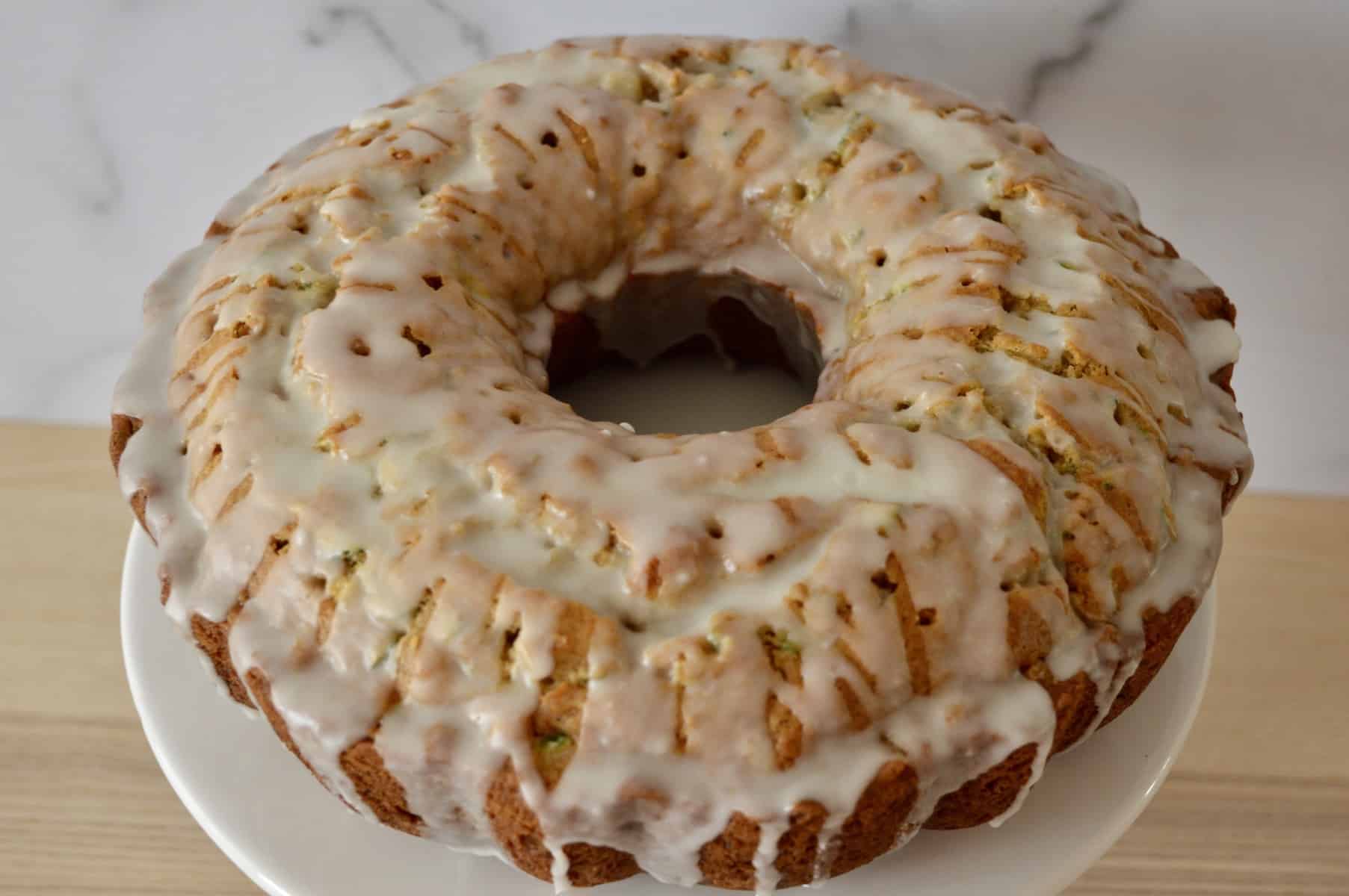 pineapple zucchini Bundt Cake with pineapple glaze drizzled over it. 